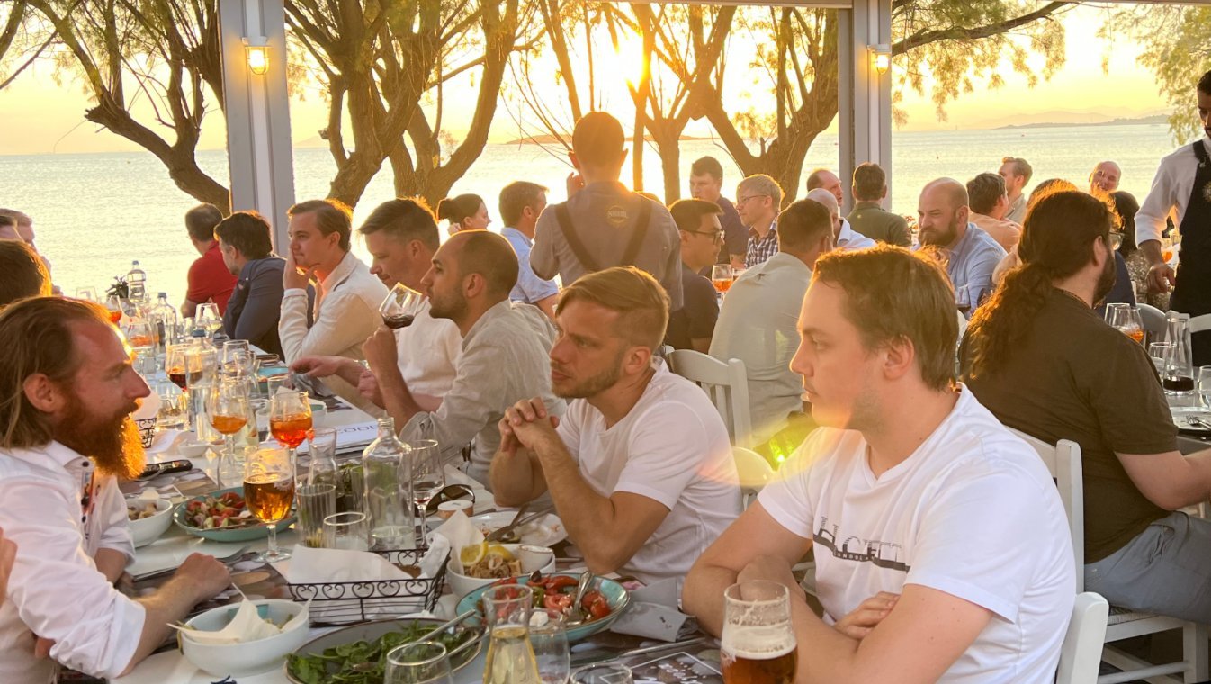 DevCode-kollegor på sommarkonferens vid havet i solnedgång